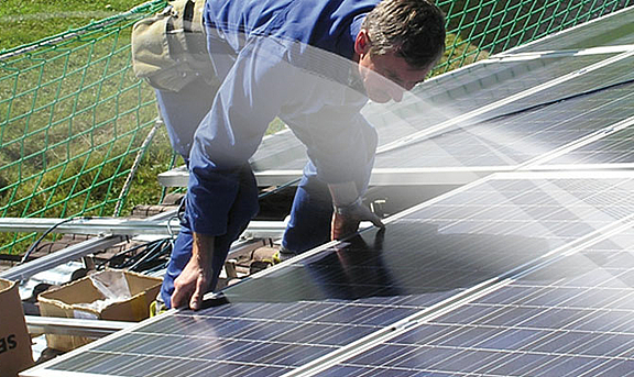 Monteuer bei der Befestigung von Photovoltaik Modulen 